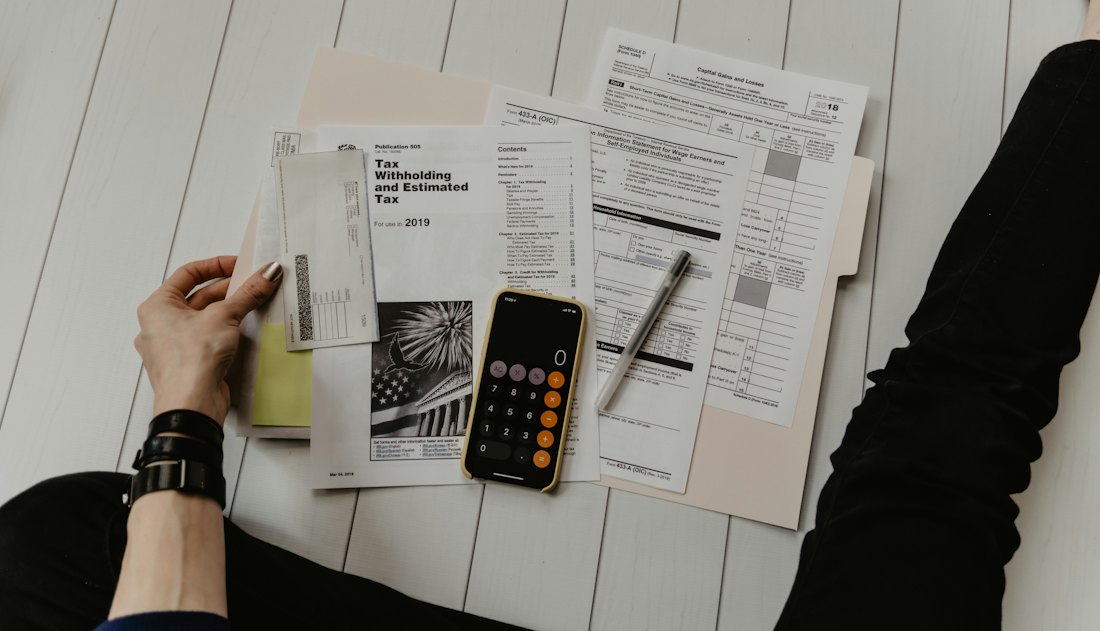 Financial paperwork, a calculator and a notebook on a desk